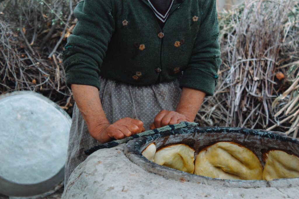 A woman baking traditional bread in a stone oven in rural Aghdash, Azerbaijan.